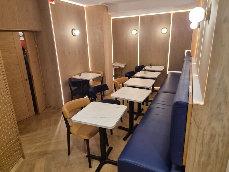 Finished dining room at Lazeez Mayfair with oak panelling, concealed LED reveals and navy banquette seating