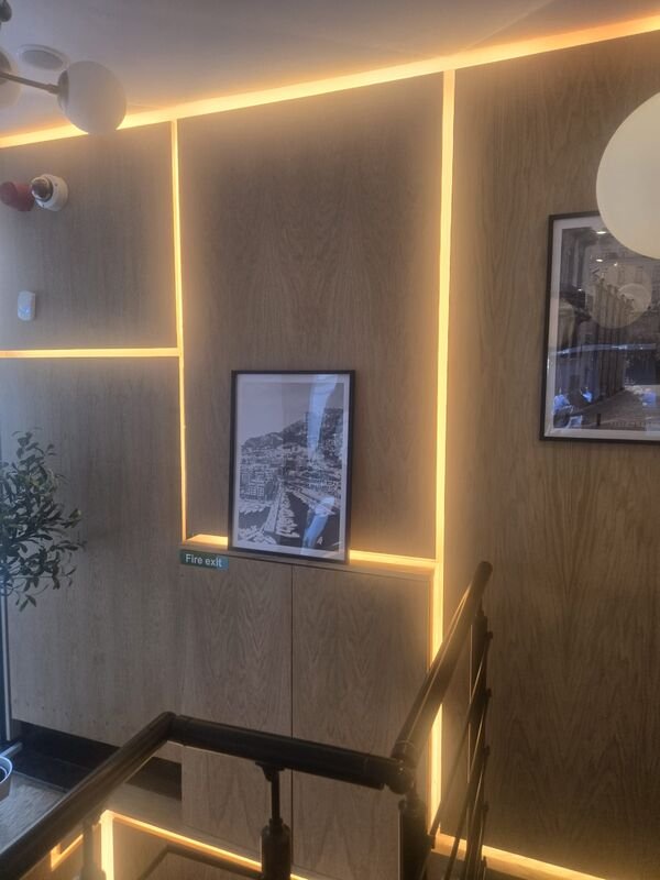Detail of the oak wall panelling with concealed LED lighting reveal and framed artwork